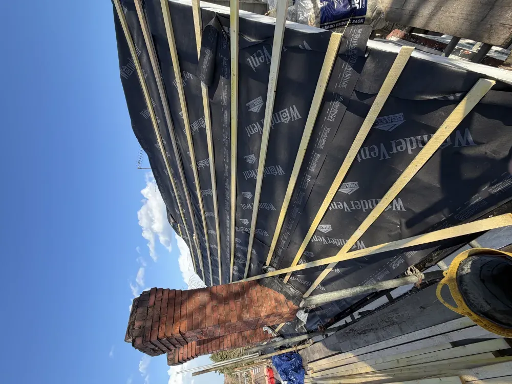 Breathable membrane and new battens fitted beside two brick chimneys during a re-roof