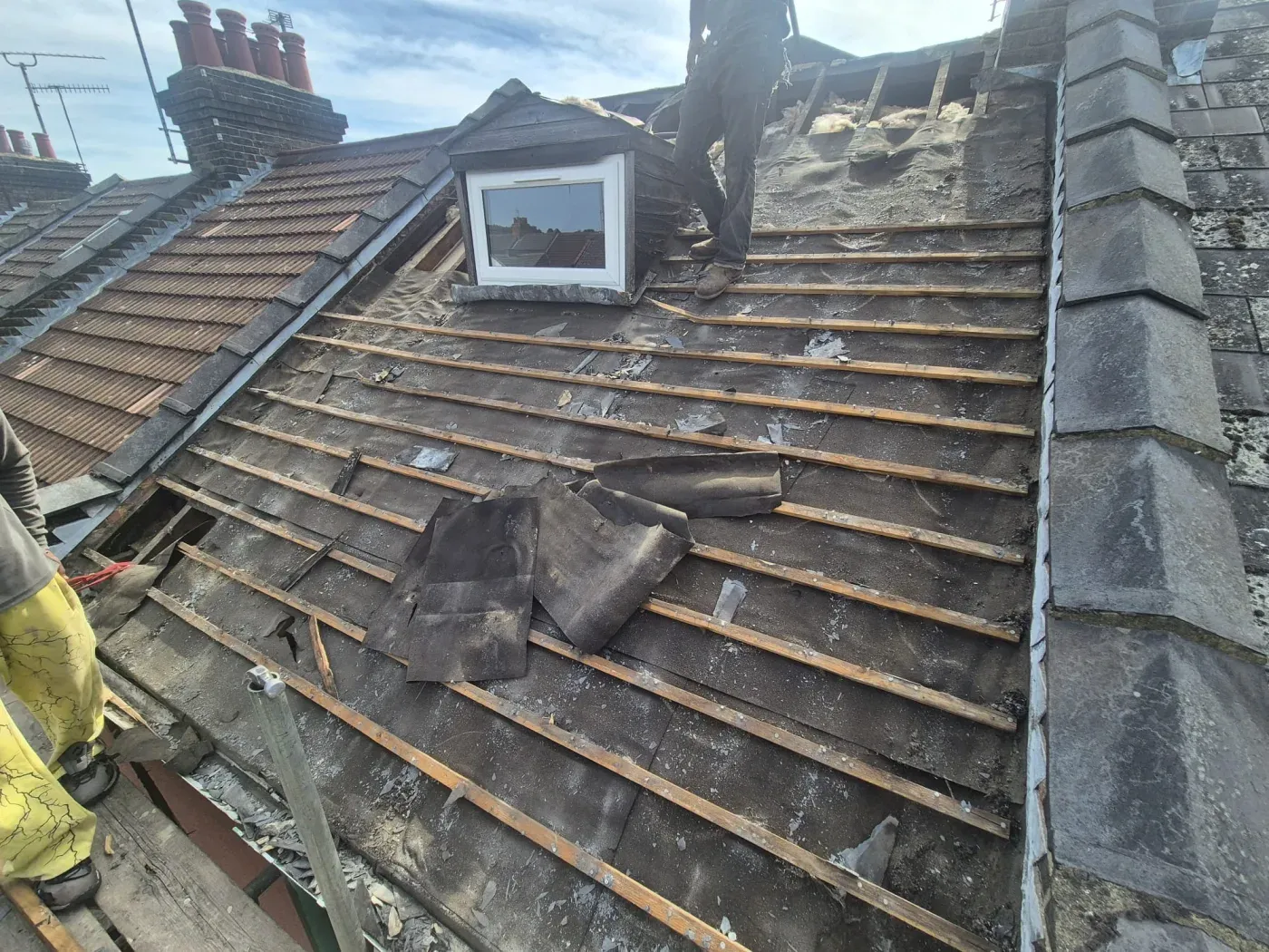 Roof stripped back to worn felt and battens before urgent re-tiling